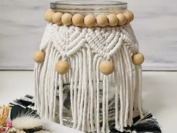 Glass container with macrame decoration and wooden beads on the edge