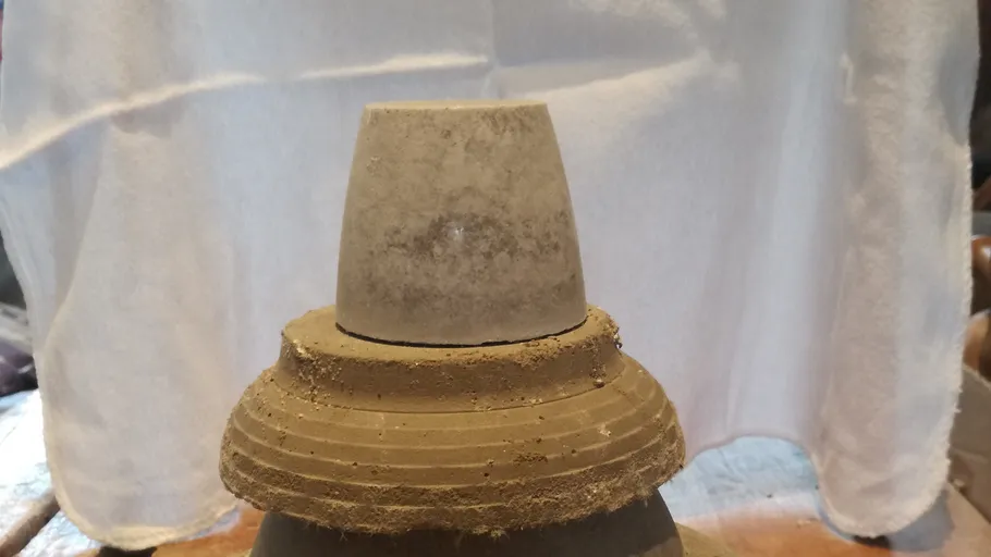 Stone object on pottery with white background.