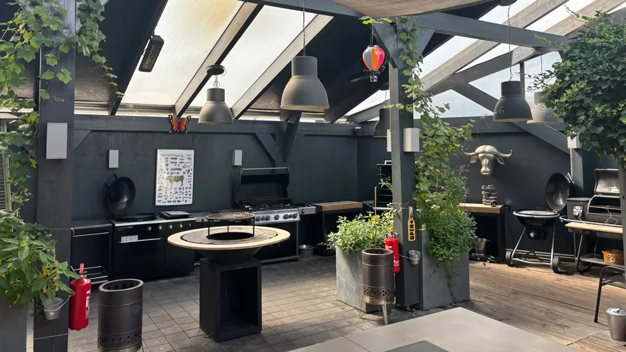 Außenküche mit Grill unter einer Pergola.