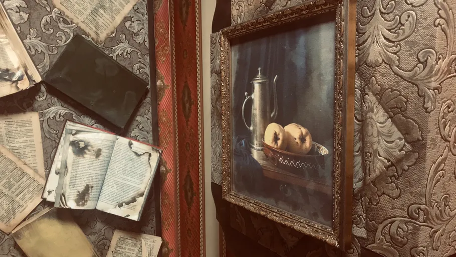 Framed still life painting on textured wall.