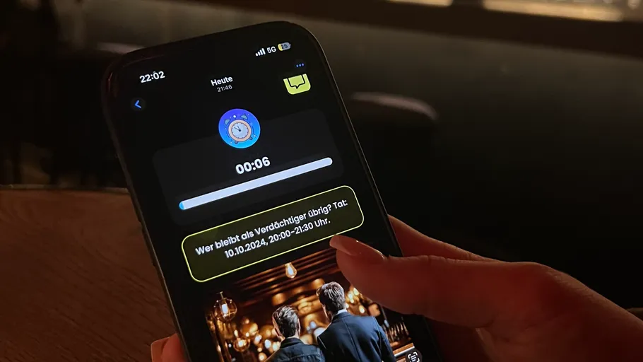 Hand hält Smartphone mit laufendem Timer.