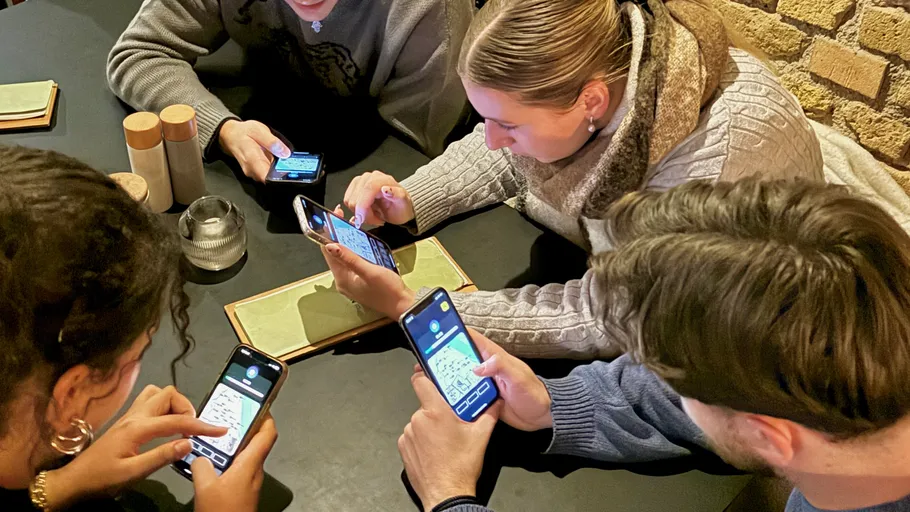 Menschen nutzen Smartphones am Esstisch.