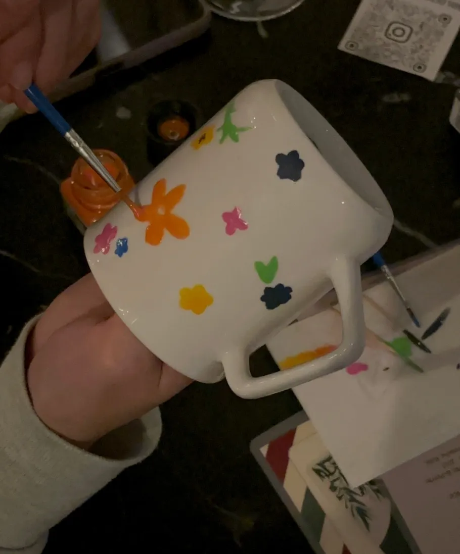 Hand bemalt weiße Tasse mit bunten Blumen.