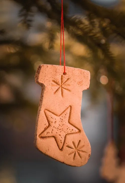 Clay stocking ornament hanging on tree.