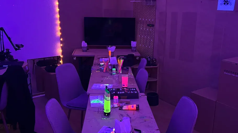 Leuchtende Gegenstände auf Tisch in dunklem Raum.