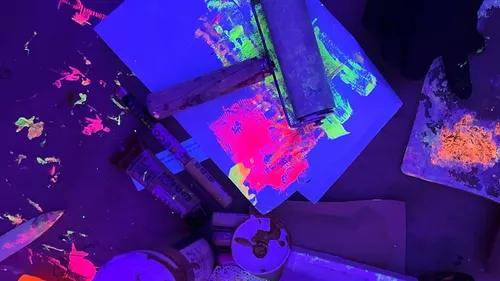 Neonfarben leuchten unter Schwarzlicht in dunklem Raum.