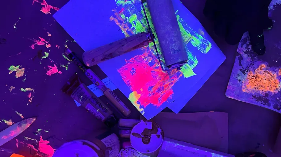 Neonfarben leuchten unter Schwarzlicht in dunklem Raum.