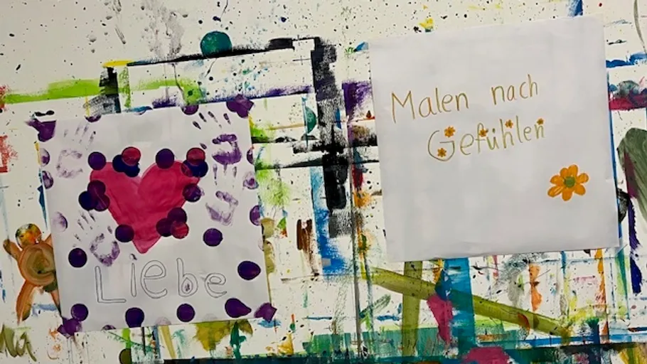 Zwei bunte Gemälde an gesprenkelter Wand.