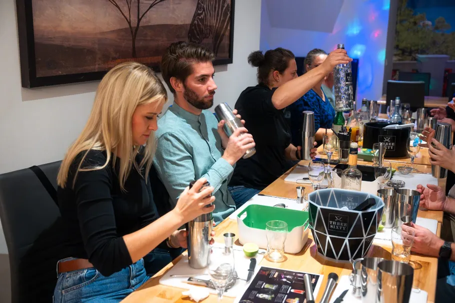 Leute schütteln Cocktailshaker an einer Bar.