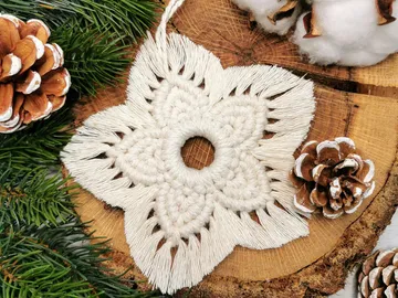 White, woven decoration is placed on a natural wooden background.