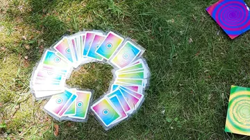 Colorful cards arranged in a circle on grass.