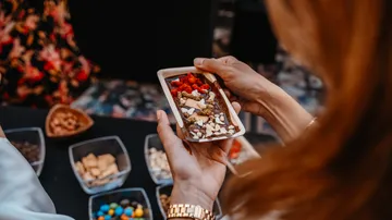 Person holding chocolate bar with mixed toppings.