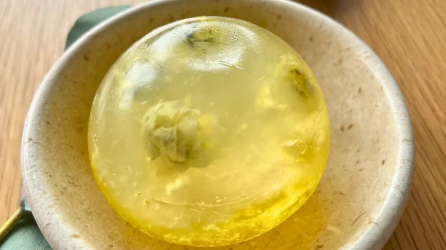 Yellow jelly ball in a ceramic bowl.