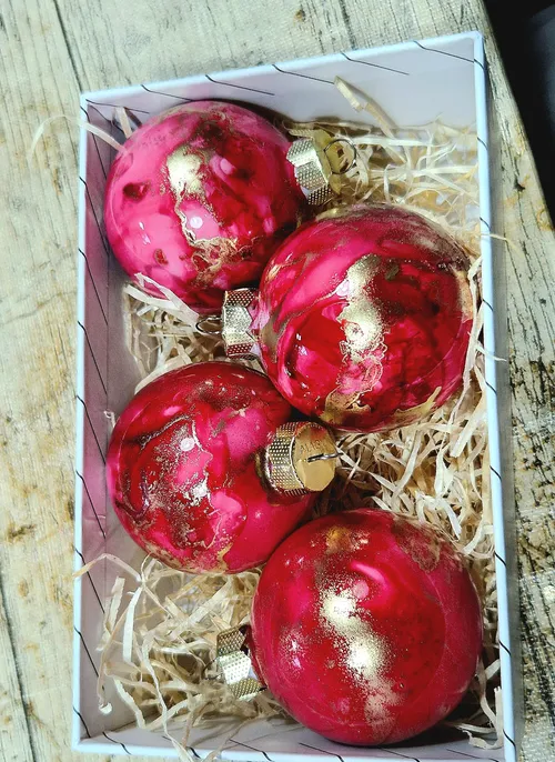 Rote und goldene Ornamente in einer Schachtel.