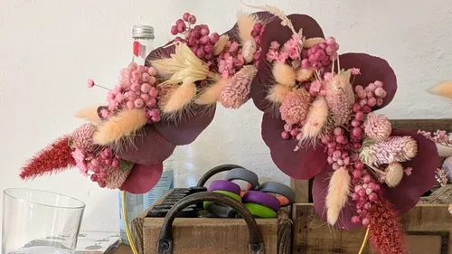 Blumenarrangement mit rosa und roten Blumen drinnen.