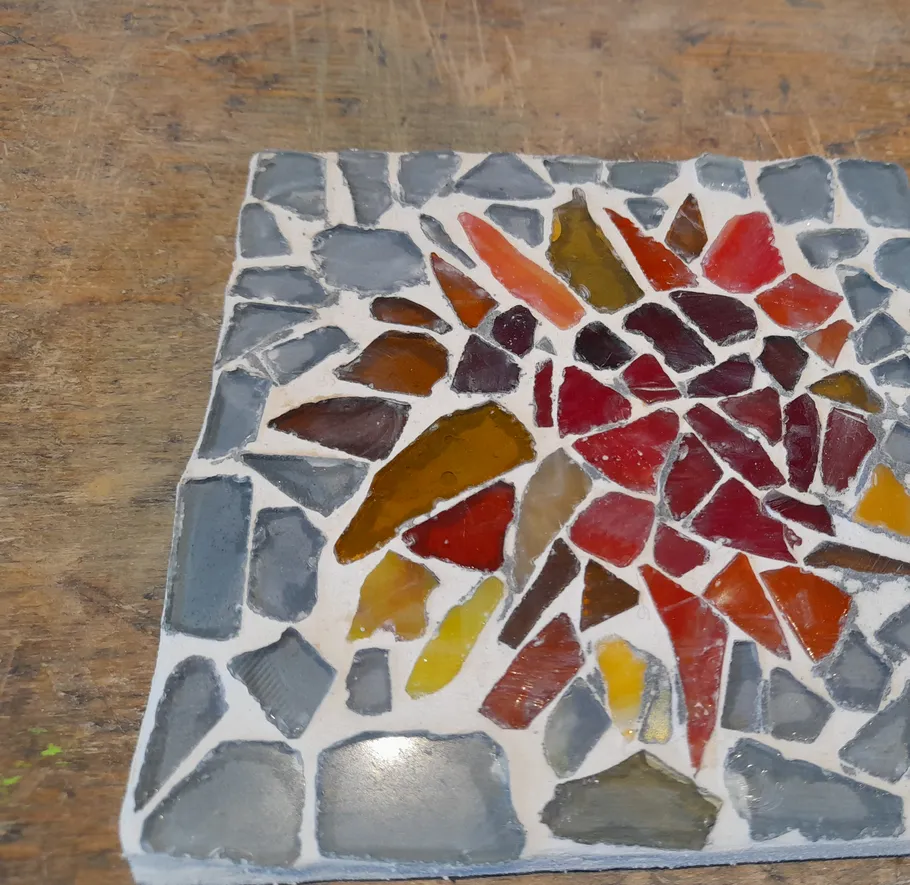 Buntes Mosaikfliese auf Holzboden.