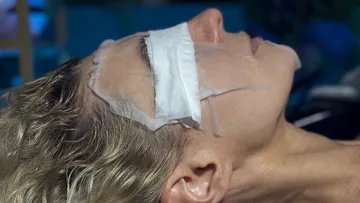 Person mit Gesichtsmaske liegt drinnen.