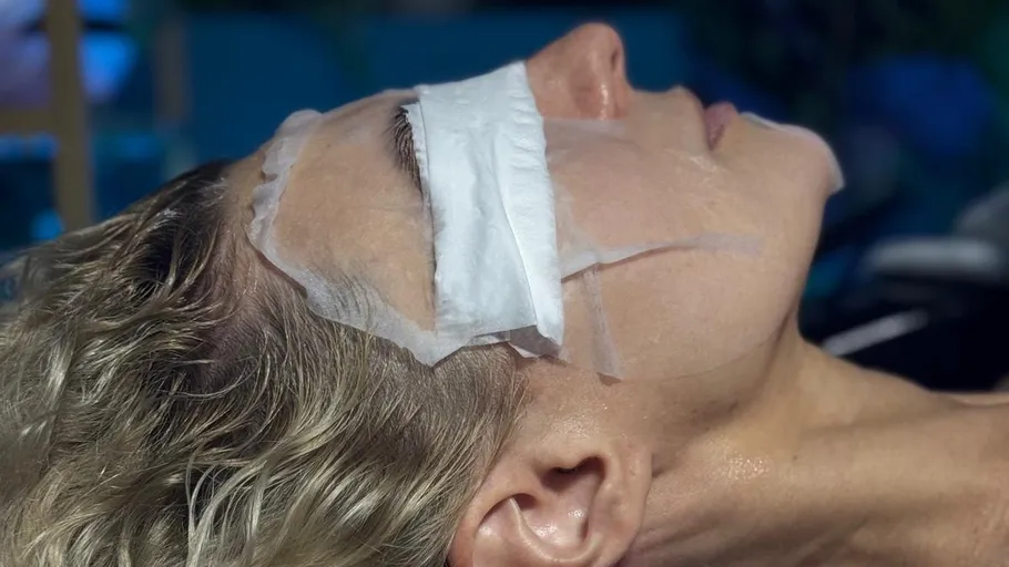 Person with facial mask lying down indoors.