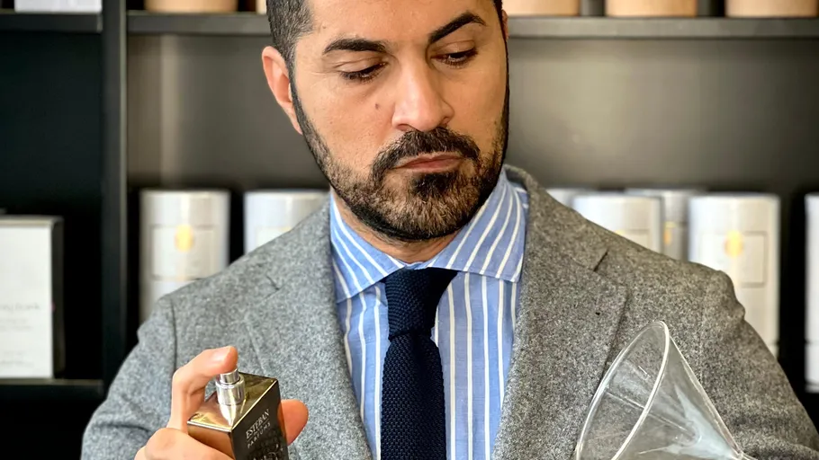 Mann sprüht Parfum in einem Laden.
