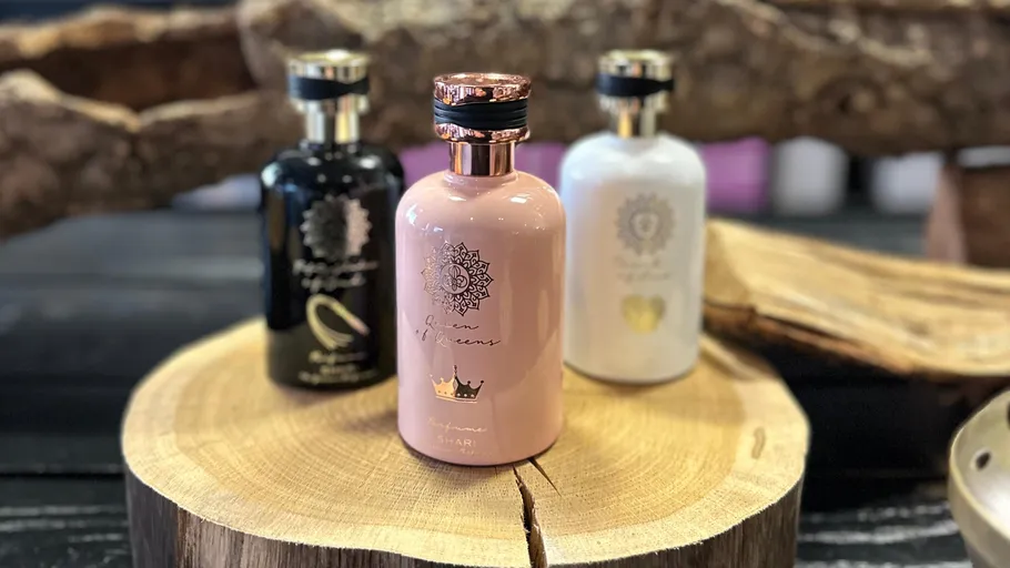 Three elegant bottles on a wood slice.