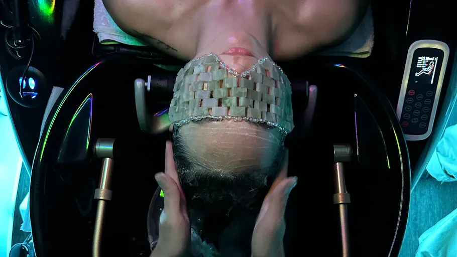 Person receiving a scalp massage in salon.