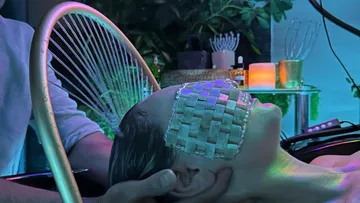 Person relaxing with woven eye mask in spa.