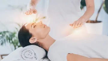 Person receiving energy healing therapy session.