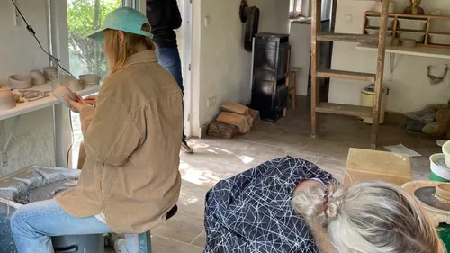 Two people crafting pottery in a workshop.