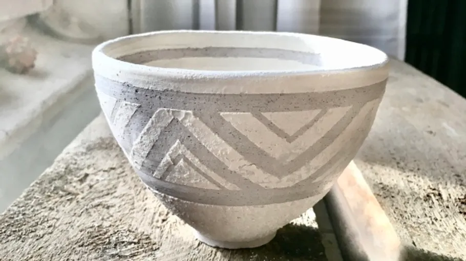 Dekorative Keramikschale auf Holztisch.