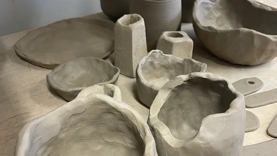 Unglazed pottery pieces on a wooden table.