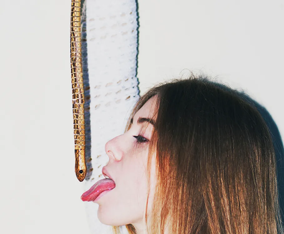 Woman sticking tongue out at hanging snake.
