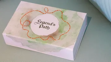 Schachtel mit Text 'Legend's Path' auf Tisch.