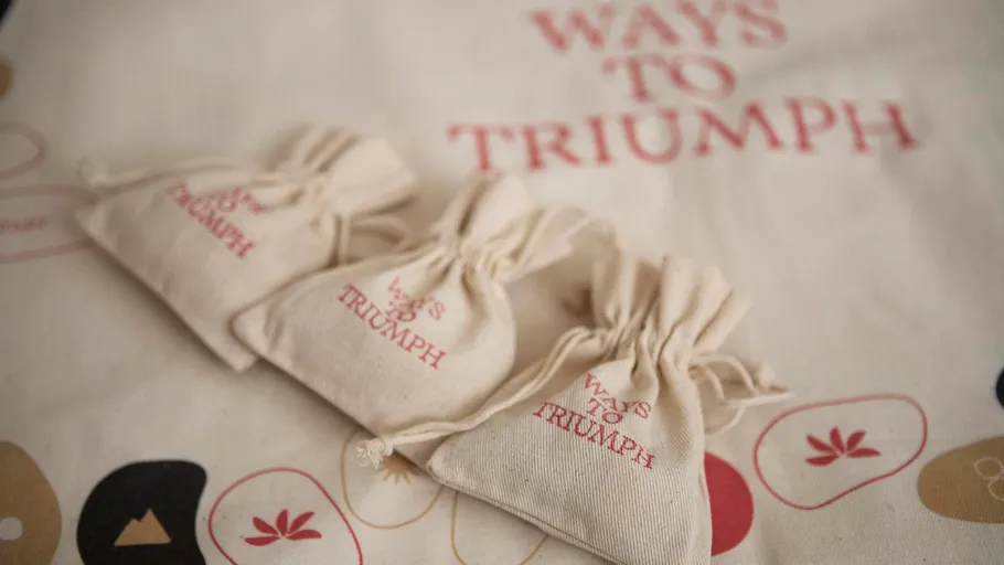 Three small bags on cloth with text.