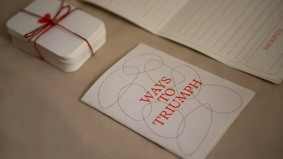 Heft mit Titel 'Ways to Triumph' auf Tisch.