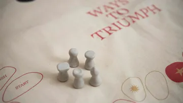 Spielfiguren auf Stoff-Spielbrettoberfläche.
