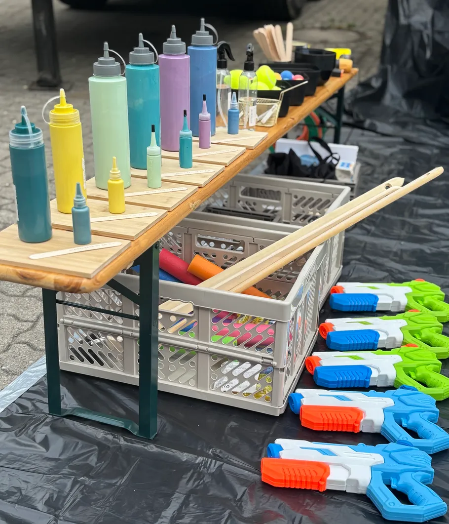 Colorful bottles and toy guns on outdoor table.