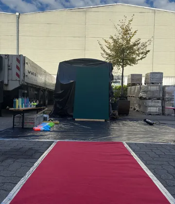 Art supplies setup on street with red carpet.