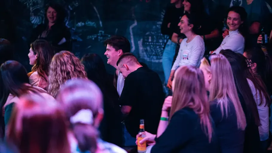 People laughing in a dimly lit venue.