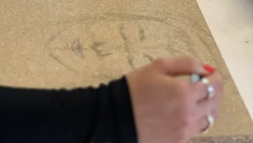 Hand drawing on cardboard surface.