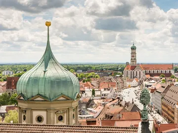Grün kupferne Kuppel überblickt Stadt mit Kirchen und Häusern.