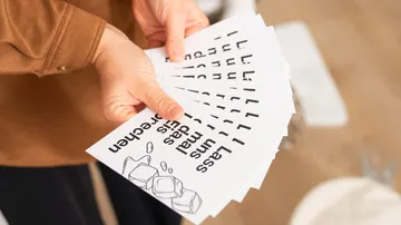 Person holding flyers with ice cube design.