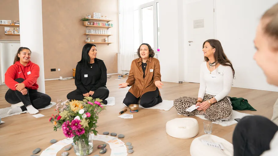 Group meditating on floor in peaceful room.