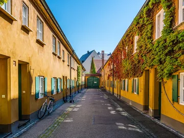 Bikes are parked in a colorful, narrow alley between houses.