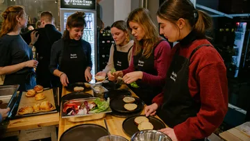 People preparing food in a kitchen setting.
