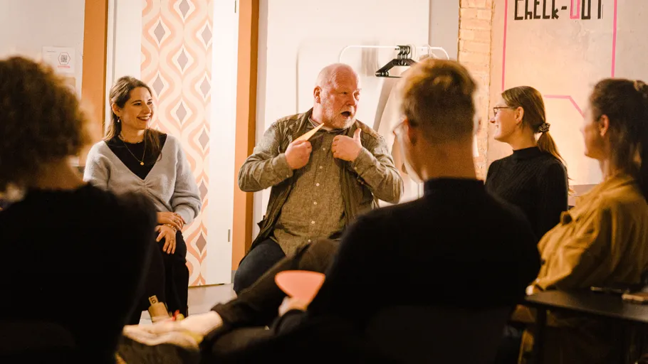 Gruppe diskutiert in gemütlicher Inneneinrichtung.