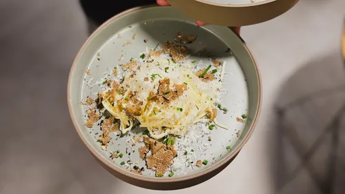 Pasta with truffles and cheese garnish.