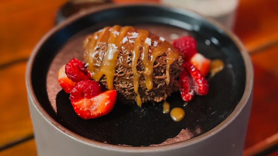Chocolate dessert with caramel and berries on plate.