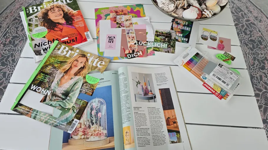 Magazines, cards, and colored pencils on table.