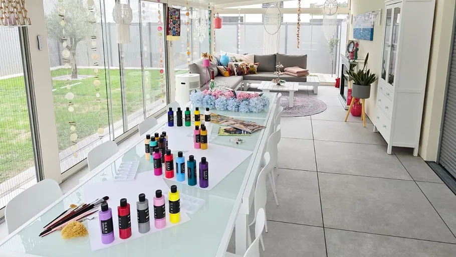 Kunstbedarf auf Tisch in hellem Wintergarten.