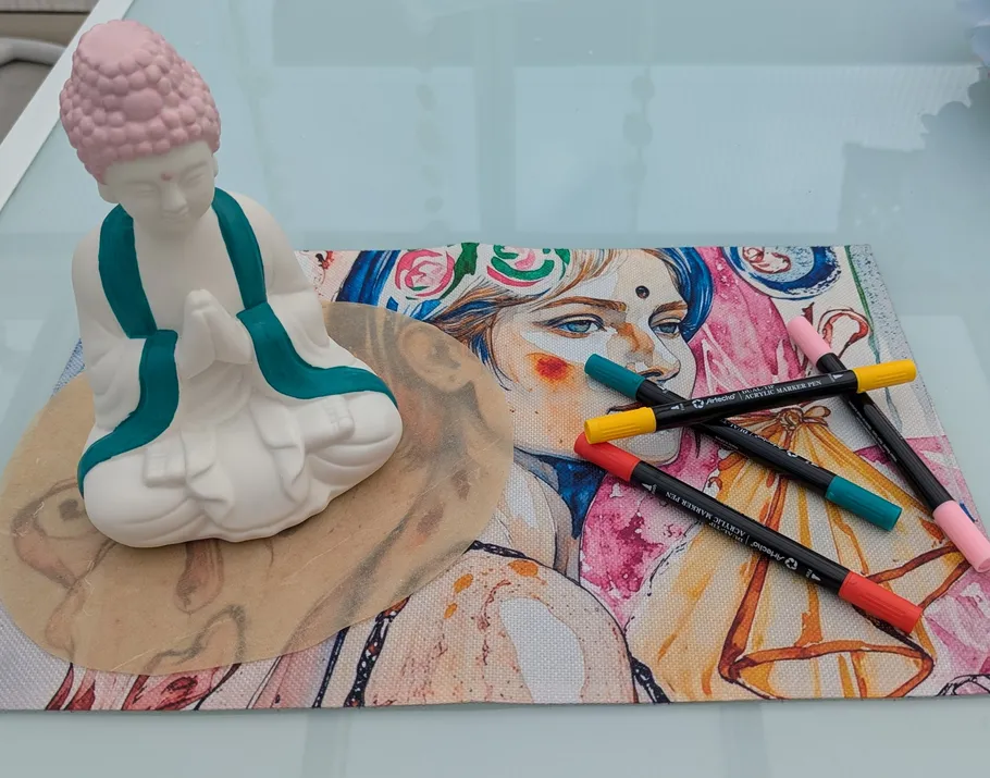 Buddha-Statue, Kunstmarker, buntes Porträt auf Tisch.